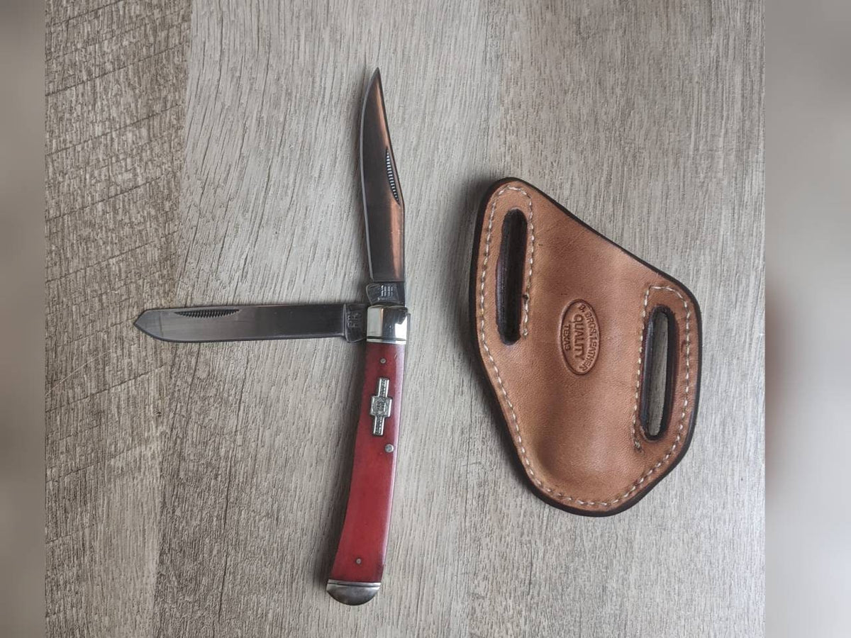 Red bone handled Rough Rider Trapper knife with matching painted floral carved chocolate Leather Pancake Style sheath