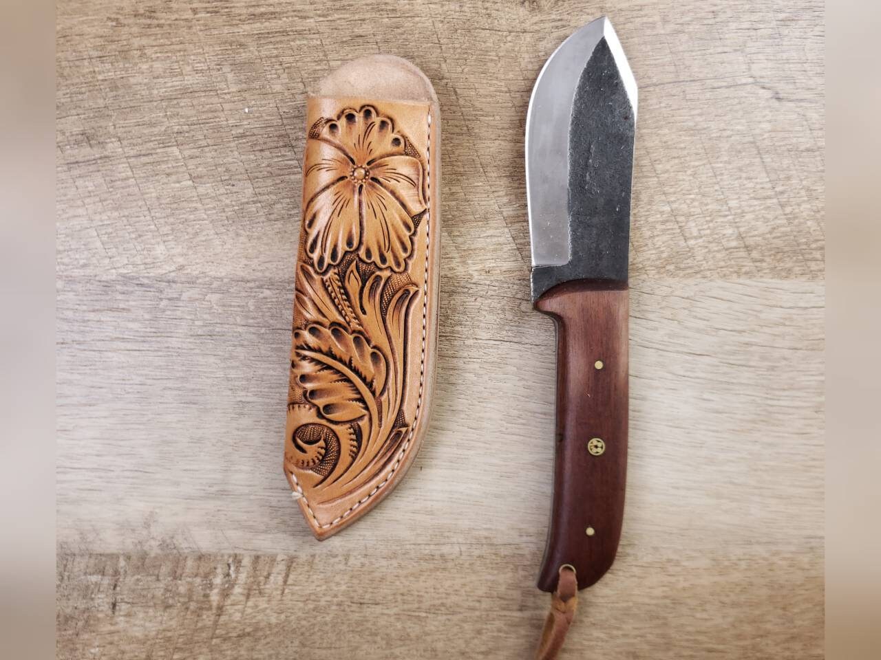 1095 forged hunting knife with a tooled leather angled sheath