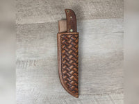 1095 forged hunting knife with a tooled basket weave leather straight hang sheath