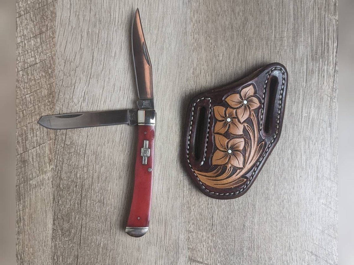 Red bone handled Rough Rider Trapper knife with matching painted floral carved chocolate Leather Pancake Style sheath