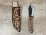 1095 forged hunting knife with a tooled oak leaf leather straight hang sheath