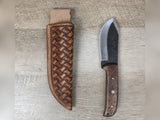 1095 forged hunting knife with a tooled basket weave leather straight hang sheath