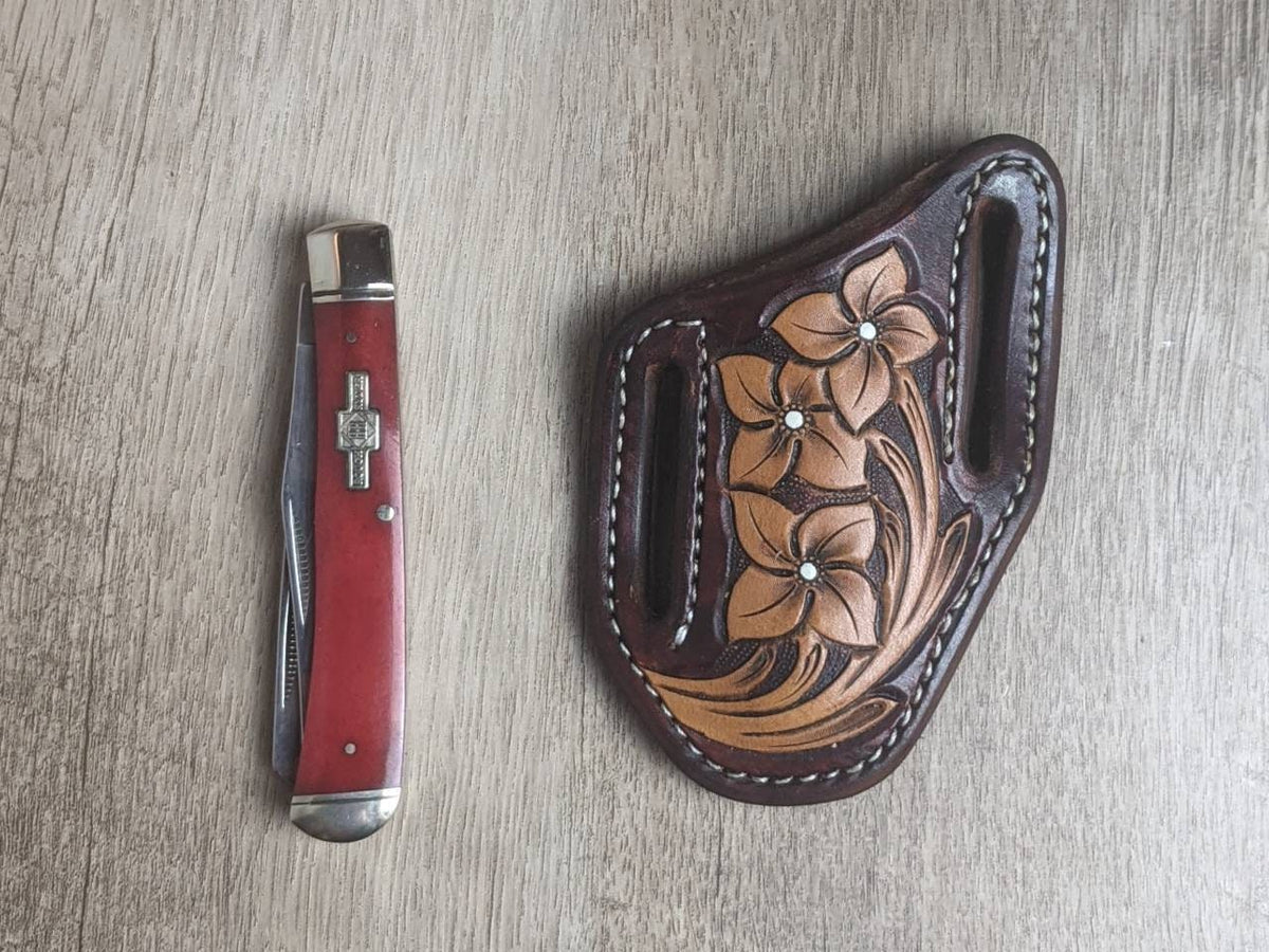 Red bone handled Rough Rider Trapper knife with matching painted floral carved chocolate Leather Pancake Style sheath
